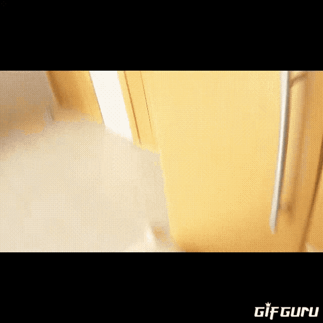 a puppy is standing next to a wooden door and looking at the camera .