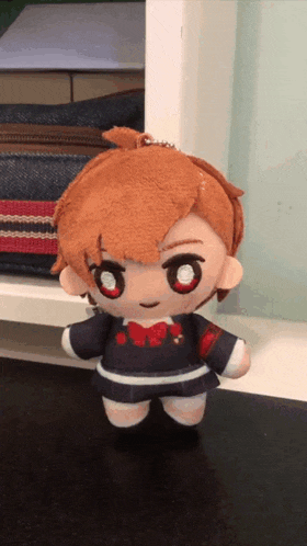 a stuffed doll with red eyes and a red bow