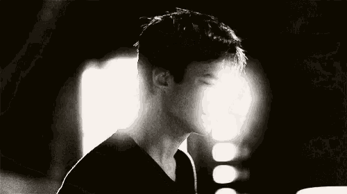 a black and white photo of a man in a dark room