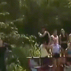 a group of people are standing in a dark room with their arms in the air