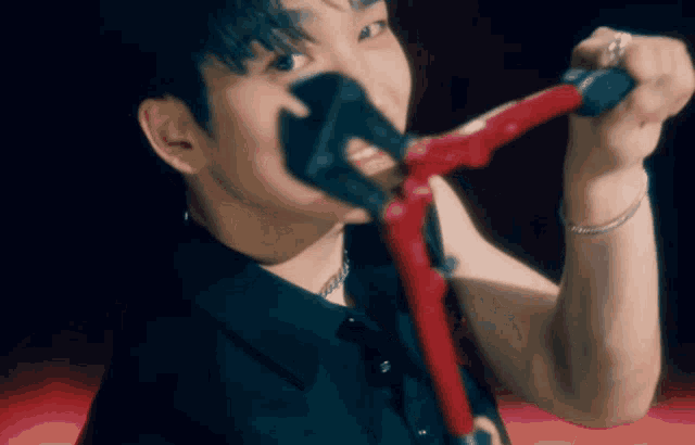 a man is singing into a microphone with a red handle