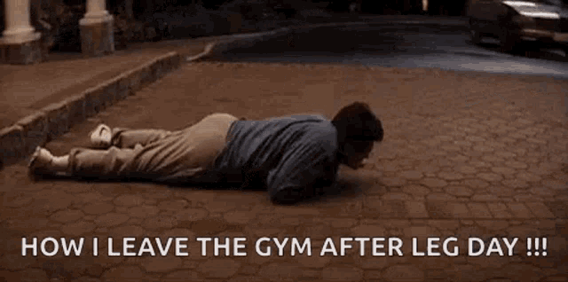 a man is laying on the ground in front of a car .