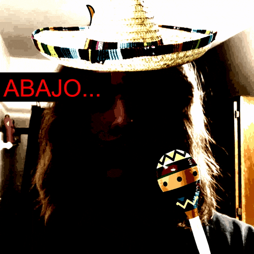a person wearing a sombrero and holding a maraca with abajo written in red behind them