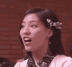 a close up of a woman 's face with her mouth open and her eyes closed .