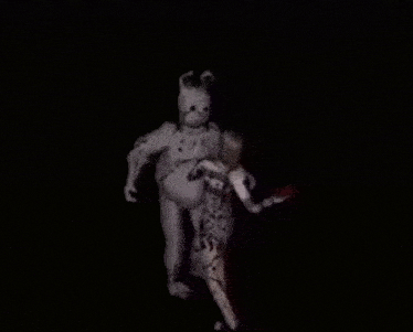 a rabbit is holding a person in its arms in a dark room .