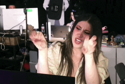 a woman is sitting in front of a laptop computer and making a face .