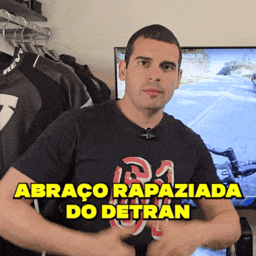 a man stands in front of a television with the words abraco rapaziada do detran written on the bottom
