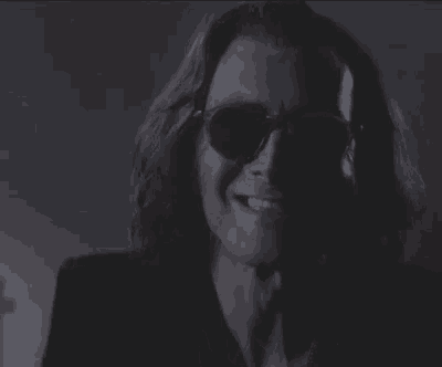 a close up of a woman wearing sunglasses and a black jacket