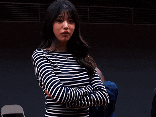 a woman wearing a striped shirt with the letter g on the front