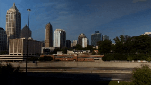 a city skyline with a sign in the foreground that says " atlanta "
