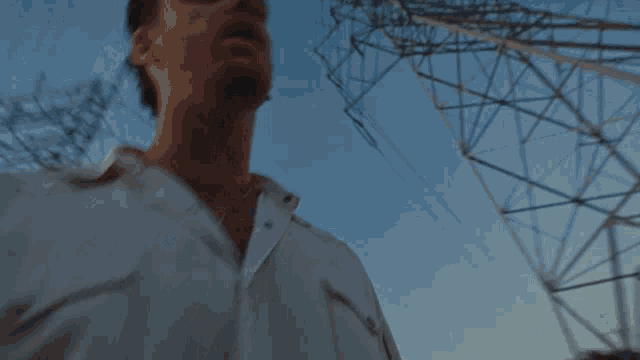 a man singing in front of a blue sky