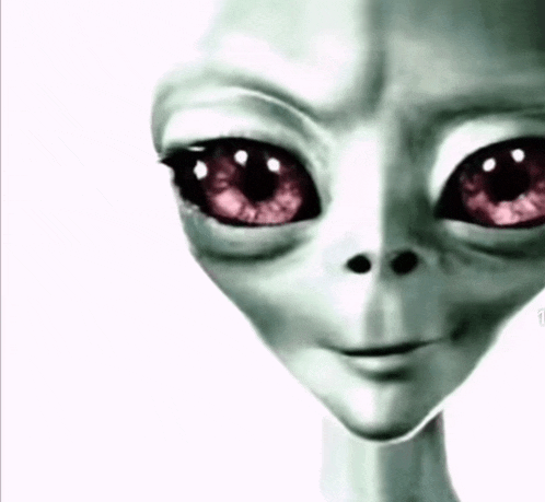 a close up of a grey alien 's face with red eyes .