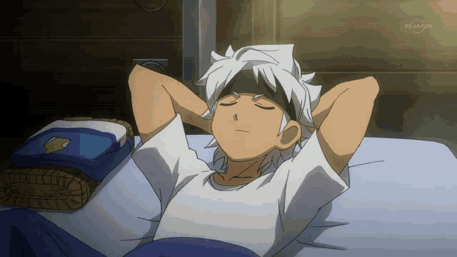 a boy is laying on a bed with his eyes closed and a tv screen behind him says bs japan