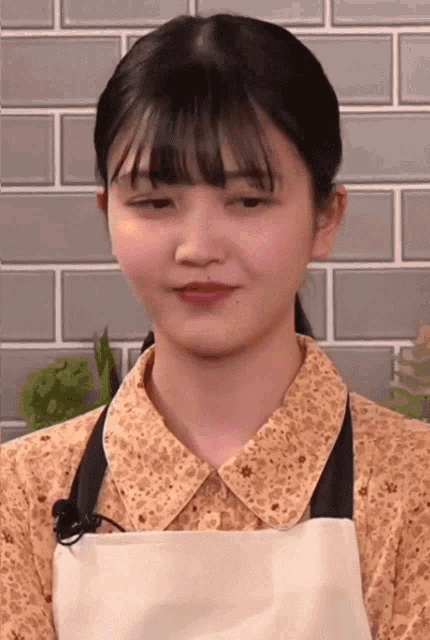 a girl wearing an apron and a collared shirt