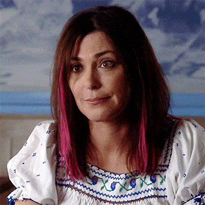 a woman with pink highlights is wearing a white top