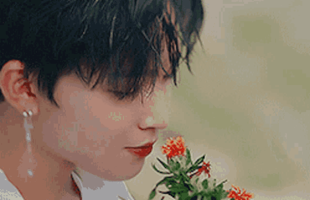 a close up of a woman smelling a flower
