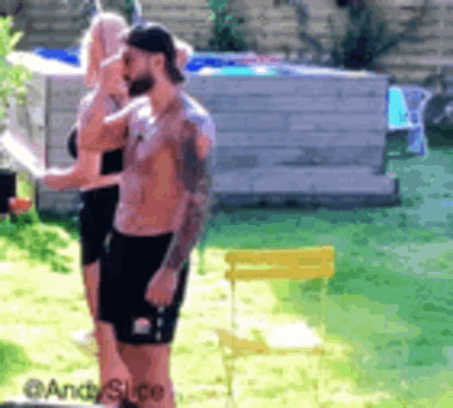 a man without a shirt is standing next to a woman .