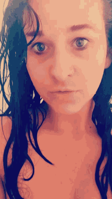 a close up of a woman 's face with wet hair and a nose ring