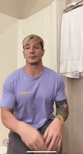a man wearing a purple t-shirt with the letter e on the bottom of it