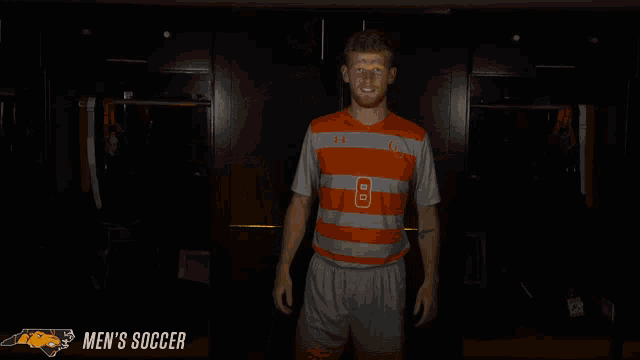 a man wearing an orange and grey striped shirt with the number 8 on it