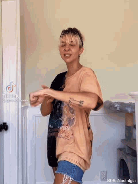 a woman with a tattoo on her arm is dancing in a room