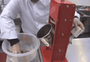 a person is pouring something into a bowl with a machine in the background