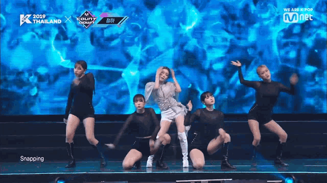 a group of women are dancing on a stage in front of a screen that says we are k pop