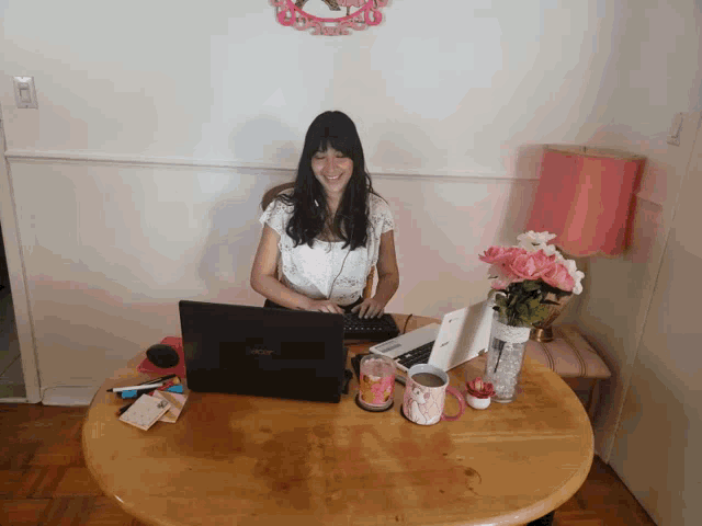 a woman sits at a table with an acer laptop on it