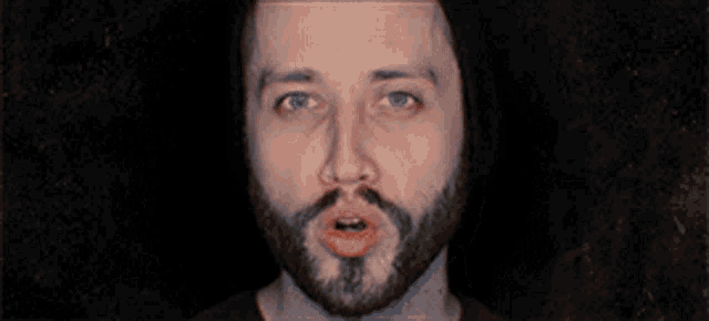 a man with a beard is making a face with his mouth wide open