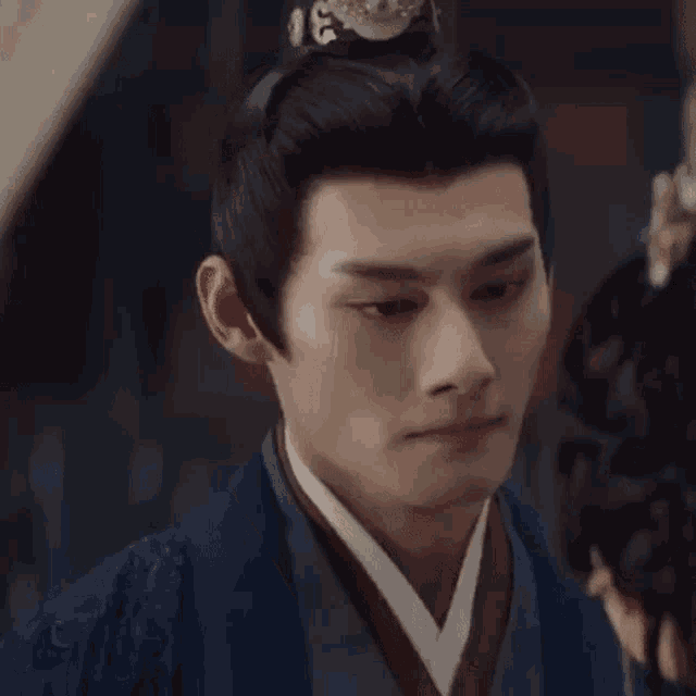 a close up of a man wearing a traditional costume and a crown .