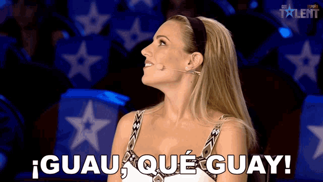 a woman sitting in front of a microphone with the words guau que guay written on the screen