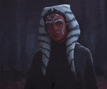 a woman with a tiger mask on her head holds a light saber