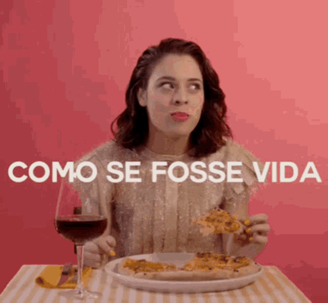 a woman is sitting at a table with a plate of pizza and a glass of wine and the words como se fosse vida behind her
