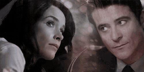 a man and a woman are looking at each other in a mirror .