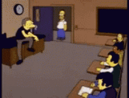 a group of people are sitting at desks in a classroom with a clock on the wall