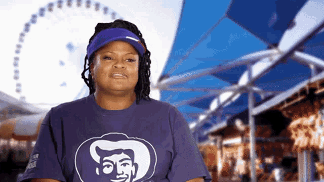a woman wearing a purple shirt with a man 's head on it