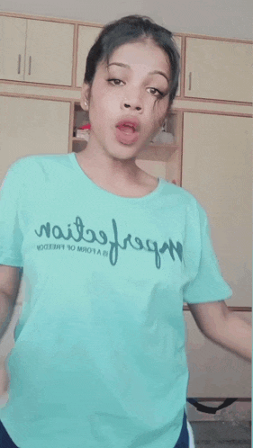 a woman wearing a blue t-shirt that says wait free on it