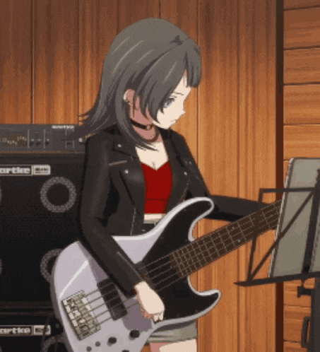 a girl is playing a guitar in front of an orange amp