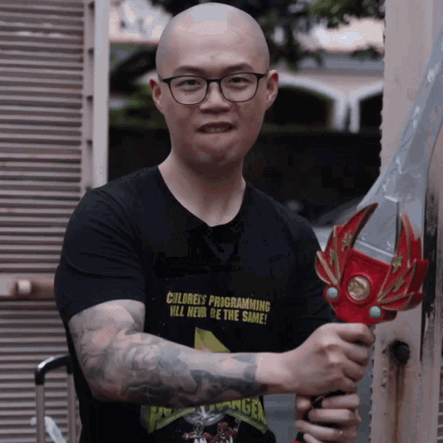 a man wearing a shirt that says children 's programming will never be the same holds a toy sword