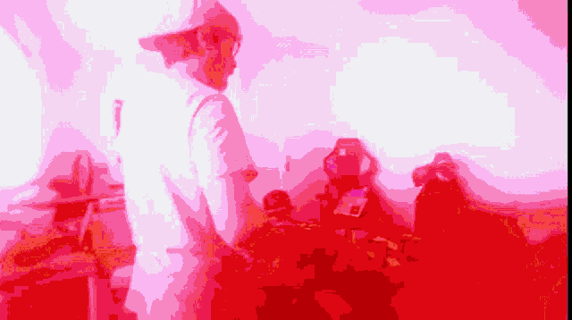 a man in a white shirt is standing in front of a red background