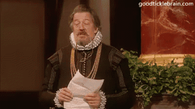 a man in a medieval costume is holding a piece of paper .