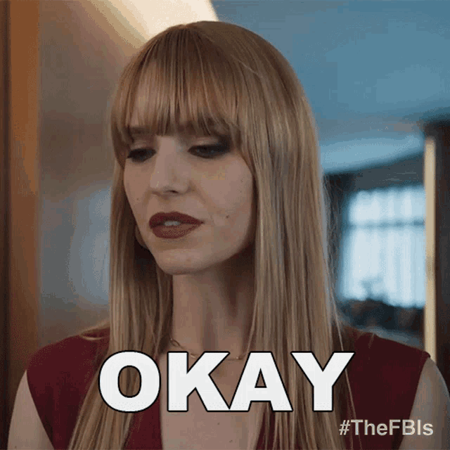 a woman with long blonde hair and bangs is making an okay sign