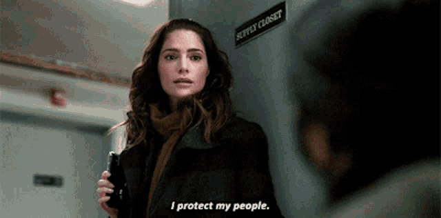 a woman is standing in front of a sign that says " supply closet "
