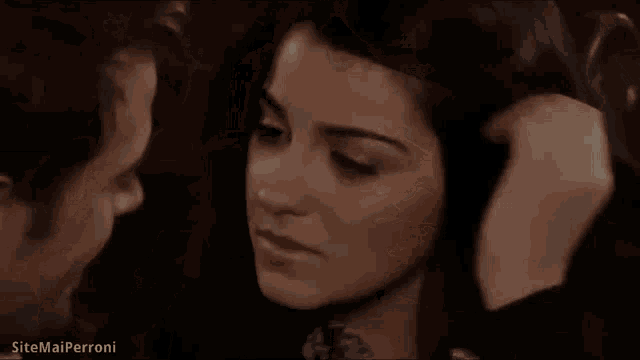 a man in a suit and tie is smiling while looking at a woman in a dark room