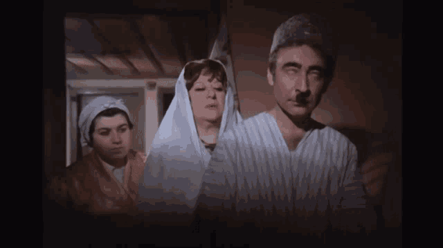 a man with a mustache is standing next to a woman with a veil on her head