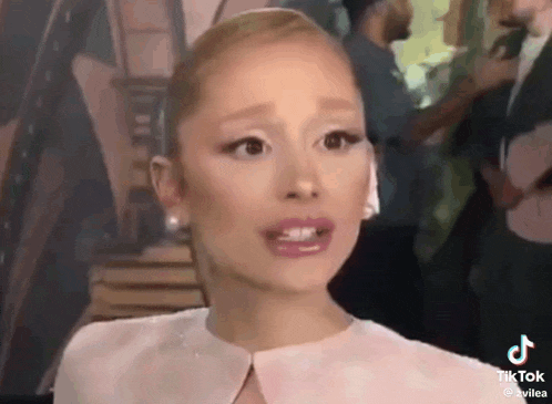 ariana grande is making a funny face while talking on a phone .