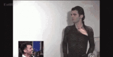 a man in a black dress is standing next to another man in a white shirt .