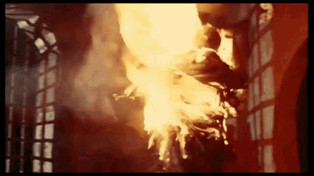 a person is standing in front of a fire with smoke coming out of their mouth