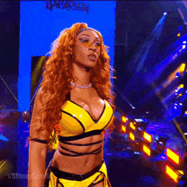 a woman in a yellow outfit is standing in front of a blue wall with the word jackson written on it