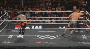 a wrestler is laying on the floor in a wrestling ring
